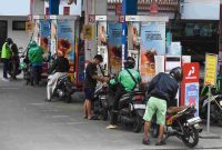 Pengendara motor mengisi bahan bakar di SPBU
