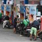 Pengendara motor mengisi bahan bakar di SPBU
